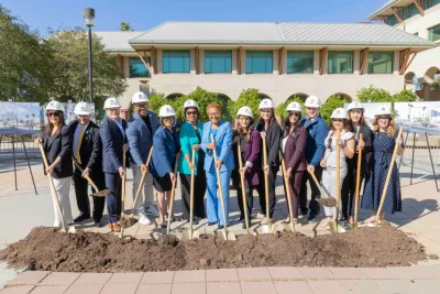 A crowd of people, including LA mayor Karen Bass, hold shovels to symbolize breaking ground on the light rail project.