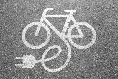 Electric bike charging logo on asphalt