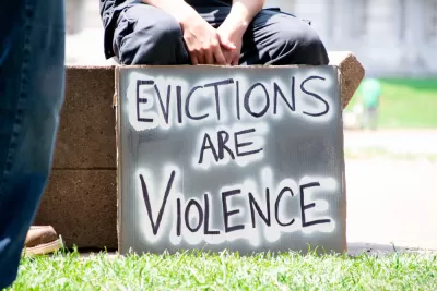 Person holding sign that says "Evictions are violence"