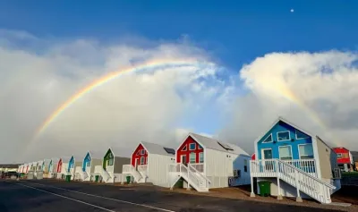 Multicolored modular emergency resnpose homes in Lahaina, Hawaii with rainbow in background.