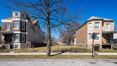 Vacant lot between two two-story residential buildings in Chicago, Illinois.