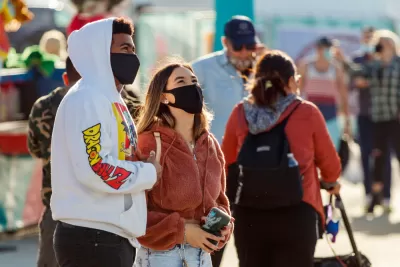 Two young people wear masks while standing outside in Florida.