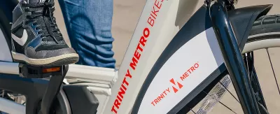 Close-up of person wearing Nike tennis shoe on Trinity Metro bike share e-bike.