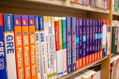 A row of GRE exam study books lined up neatly in a bookstore.
