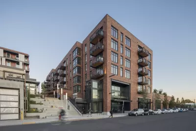 Photo of Goat Blocks development, Portland, Oregon with five-story brick building and wide concrete staircase.