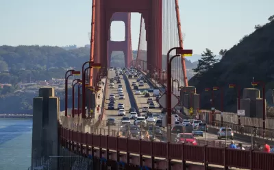 The Golden Gate bridge viewed from Marin, with cars passing in either direction on a sunny day.
