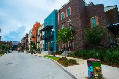 Row of multicolored three-story apartment buildings.