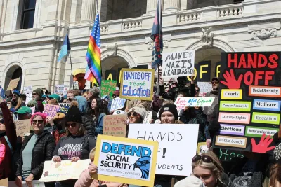 Crowd gathered with protest signs on April 5, 2025 on steps of Minnesota state capitol protesting Trump cuts to social security and other federal programs.