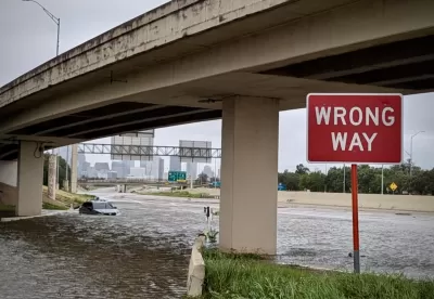 Flooded freeway underpass with red and white WRONG WAY sign in Houston, Texas during Hurricane Beryl in July 2024.