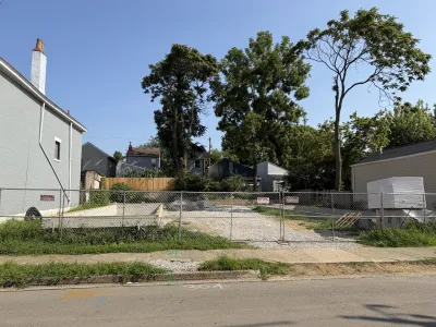 Vacant lot behind chain link fence in Covington, Kentucky.
