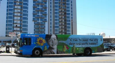 Blue Austin public transit bus with graphic reading "I ride to keep the city clean and earth happy."