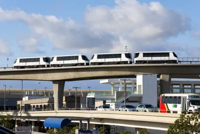 Four cars of the LAX SkyLink. They are white, and there is no clear front or back. They have black windows.