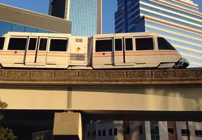 Jacksonville Skyway monorail train passing on elevated rail in front of downtown buildings