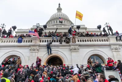 Trump supporting insurrectionists scale the walls of the U.S. Capitol Building on January 6, 2021.