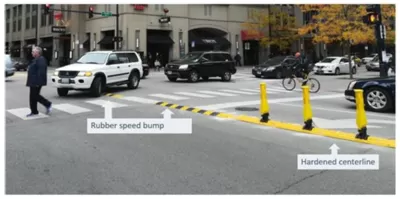 Crosswalk in Chicago with newly installed yellow delineators and speed bumps