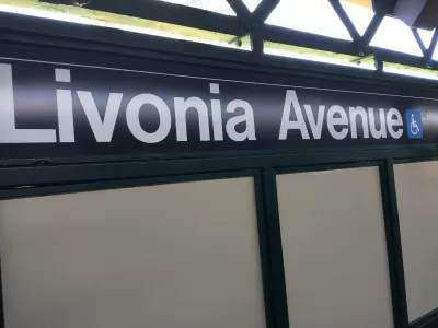 Close-up of black and white Livonia Avenue subway sign with blue accessibility symbol
