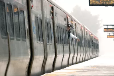 A train conductor waves at an empty platform on the Long island Rail Road system.