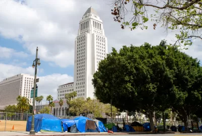 A group of tents line a street in front of Los Angeles City Hall.