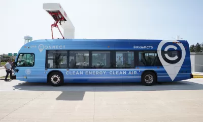 Blue electric MCTS bus sits at a charging station