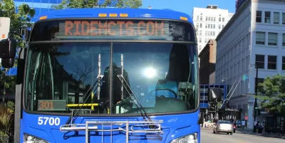 Close-up of front of blue MCTS bus with "Ride MCTS" on marquee in urban Milwaukee neighborhood