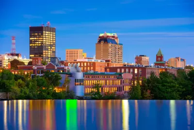 The downtown of Mancheste, New Hampshire is nestled against the Merrimack River in the final light of day. 