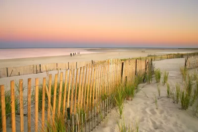 A fence shows a walkway to the beach in Cape Cod, Massachusetts.