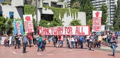 Group protesting during May Day 2017 holding sign that reads "Sanctuary for all" in San Francisco, California.
