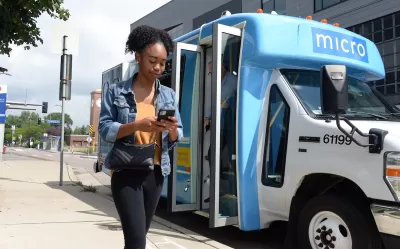 Girl walking in front og blue and white minibus with 'micro' logo in Minneapolis, Minnesota.