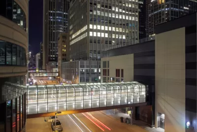 A series of pedestrian bridges, linking buildings on either side of the street, are illuminated int he night in downtown Minneapolis.