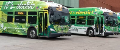 Parked green electric NJ Transit buses.