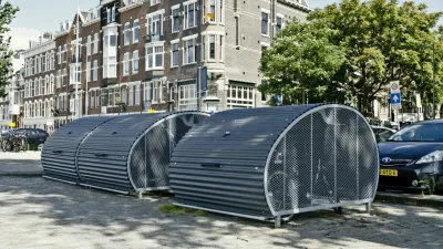 Rounded secure bike parking lockers on city street in Europe.