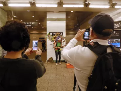A performer holding numerous instruments plays for a crowd in the New York Subway.