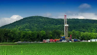 Marcellus shale gas-drilling site with tall white tower against green hills along PA Route 87, Lycoming County, Pennsylvania