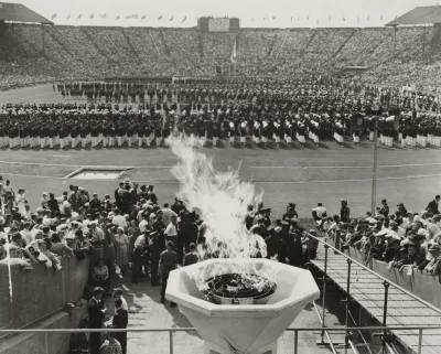 Black and white image of Olympic cauldron lit during opening ceremonies at 1948 London Olympics.