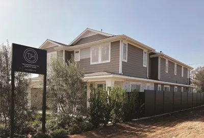 Grey two-story home rebuilt in Pacific Palisades, Los Angeles after 2025 wildfire.