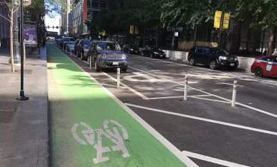 Green painted bike lane protected by rown of parking.