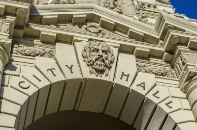 Close-up on :City Hall" carved into stone arch with gargoyle face in middle on Pasadena City hall entrance arch.