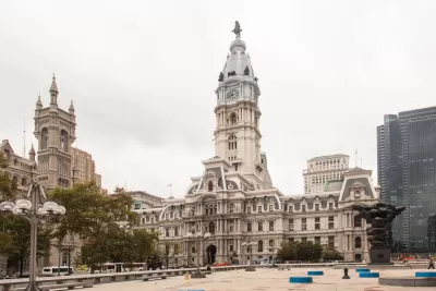 An empty pedestrian plaza is shown in front of Philadelphia City Hall.
