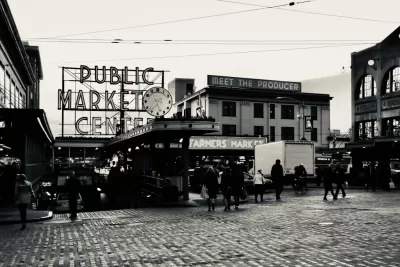 Black and white photo of Pike Place Market entrance in Seattle with "PUBLIC MARKET" and "Meet the producer" signs