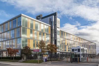 A movie studio buildiing located in Old Toronto's Port Lands is fenced off from the sidewalk and protected by a security guard station.