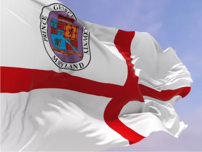 The flag of Prince George's County00a red croiss in a white field with a crest of arms in the upper left corner, blows in the wind.