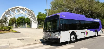 White and purple RTA bus inf ront of white archway to Armstrong transit station in New Orleans, Louisiana.