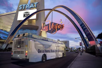 A zero-emission hydrogen fuel-cell bus under a Las Vegas sign.