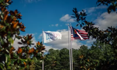 Flags on tall flagpoles with RTP logo and North Carolina flag at Research Triangle Park.