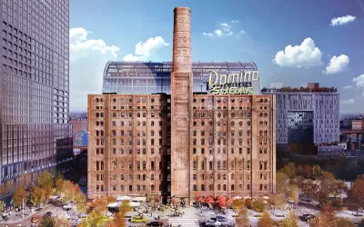 Historic brick sugar refinery building redeveloped with glass office tower inside and yellow Domino Sugar sign