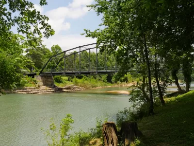 Old wooden bridge with steel railings at the War Eagle River in Rogers, Arkansas.