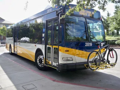 White and blue Sacramento regional transit bus with one bike on front bike rack.