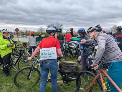 People with bike stand on lawn as part of rally to save 15th Street bike lanes in Washingotn, D.C.