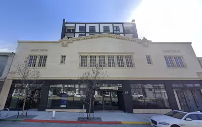 Former auto showroom converted to apartments in Oakland, California with vintage facade and new tower rising above