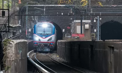 Amtrak train coming out of stone tunnel